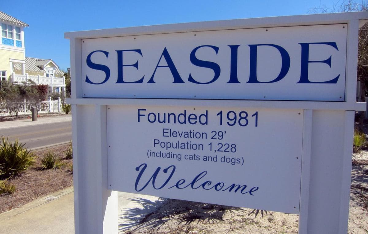Seaside Florida welcome sign and community information, 30A real estate market analysis.