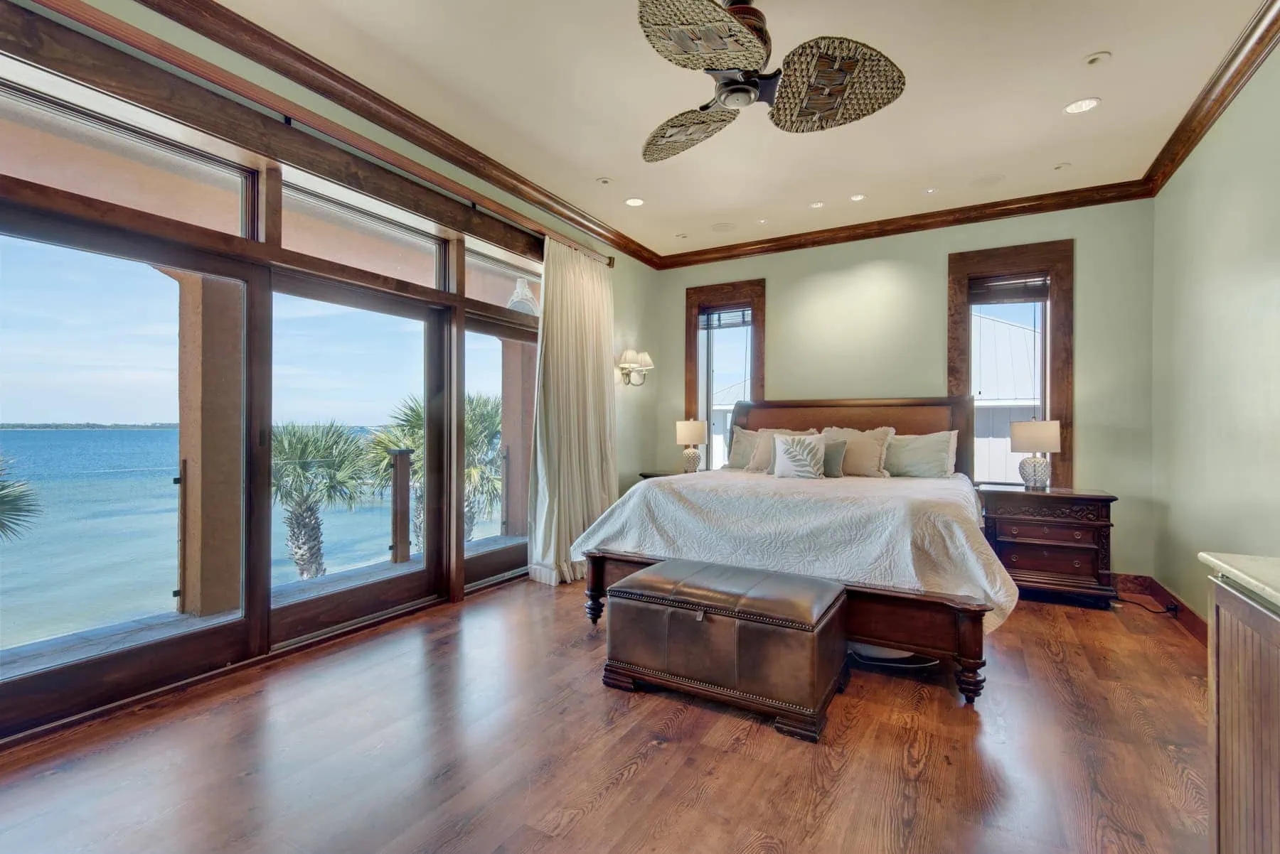 Mediterranean estate bedroom with water views and wood flooring.