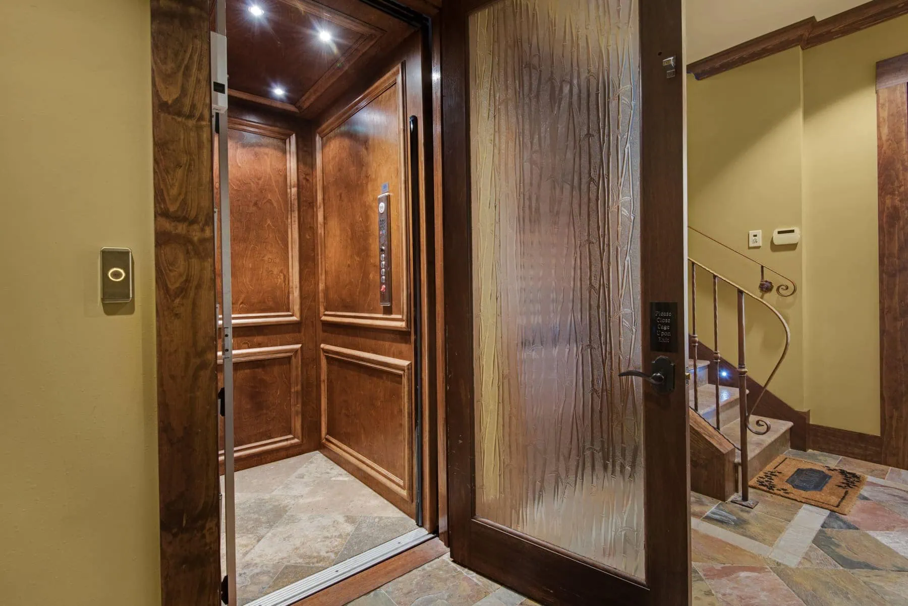 Mediterranean Estate interior featuring a wood elevator and textured glass door.