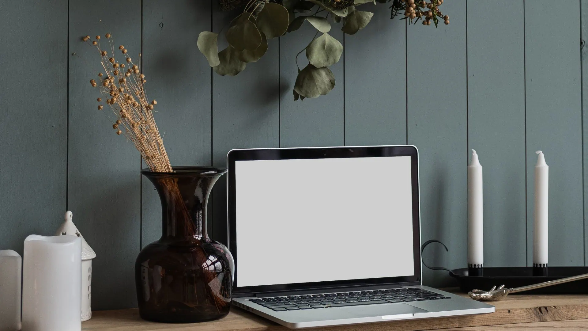Minimalist decor with laptop and candles illustrating neutral home staging for sale.