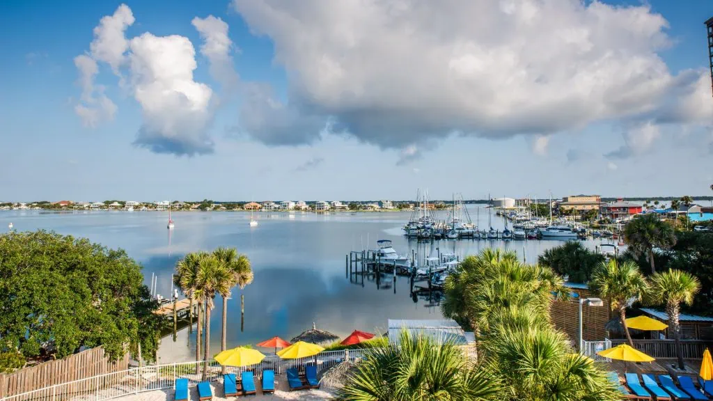 Pensacola waterfront scene with boats and beach umbrellas, showcasing recreational activities and coastal beauty.